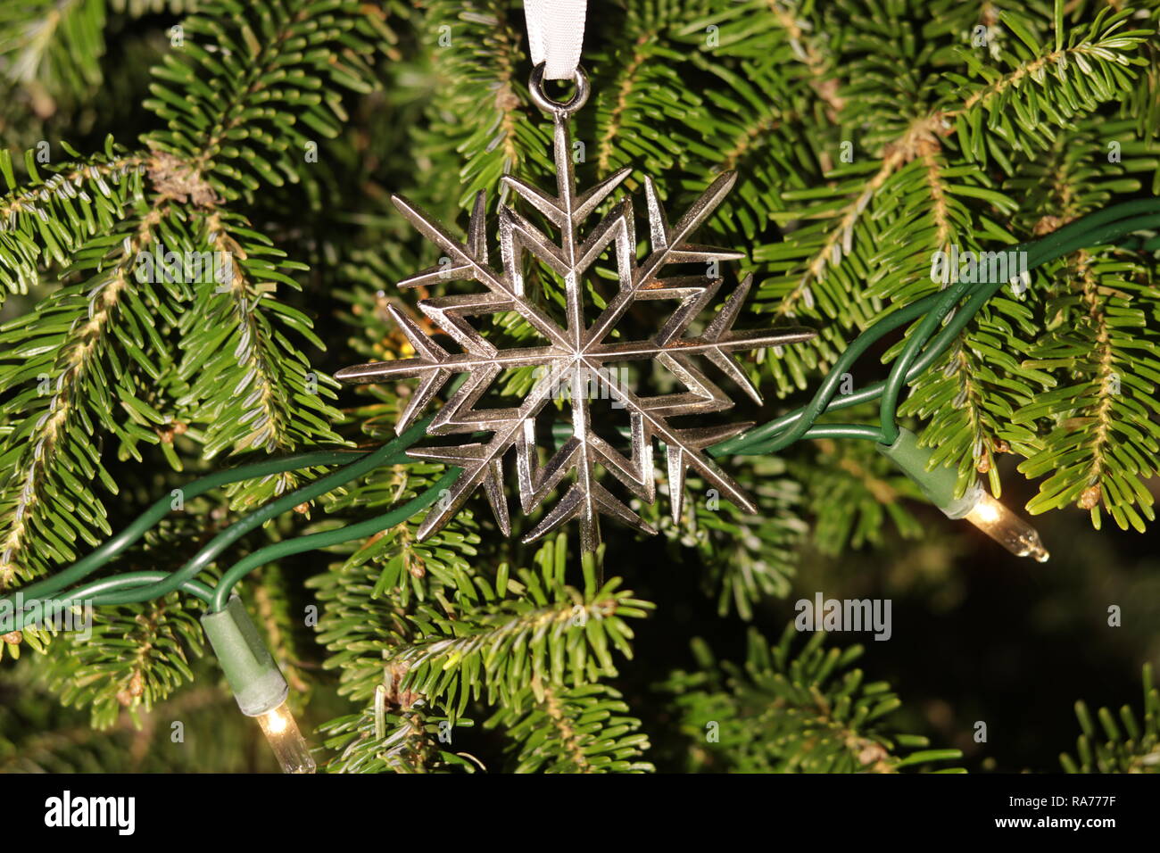 Eine schöne Schneeflocke Ornament auf einen echten Baum Stockfoto