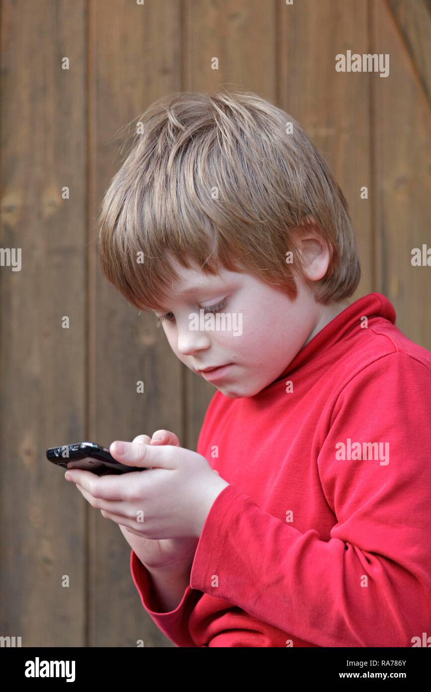 Junge schriftlich eine SMS-Nachricht Stockfoto
