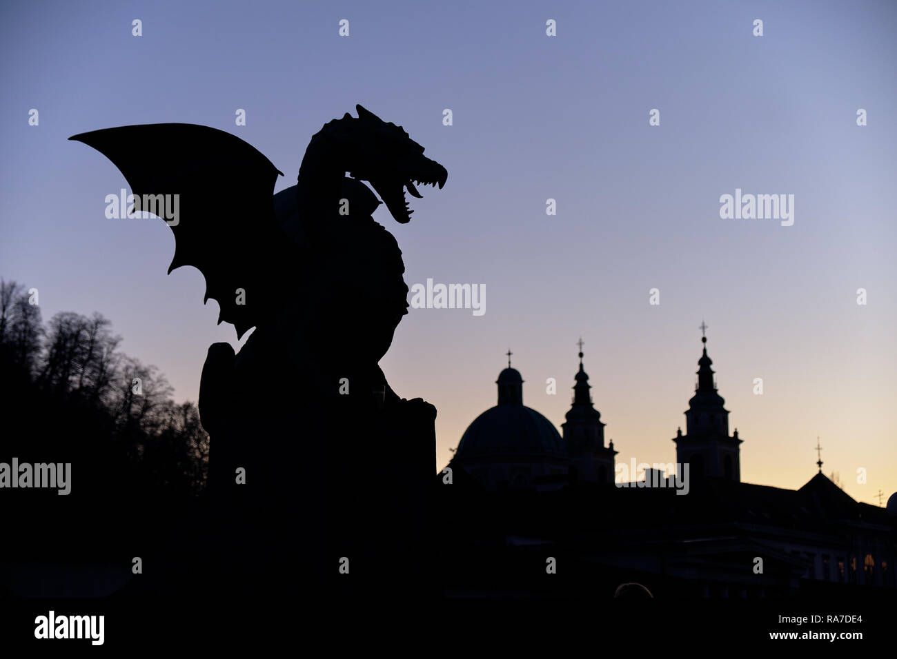 Das Feuer drache Symbol der Stadt Ljubljana city Brücke gesehen. Nacht Silhouette gegen lila Himmel, mit Skyline Stockfoto