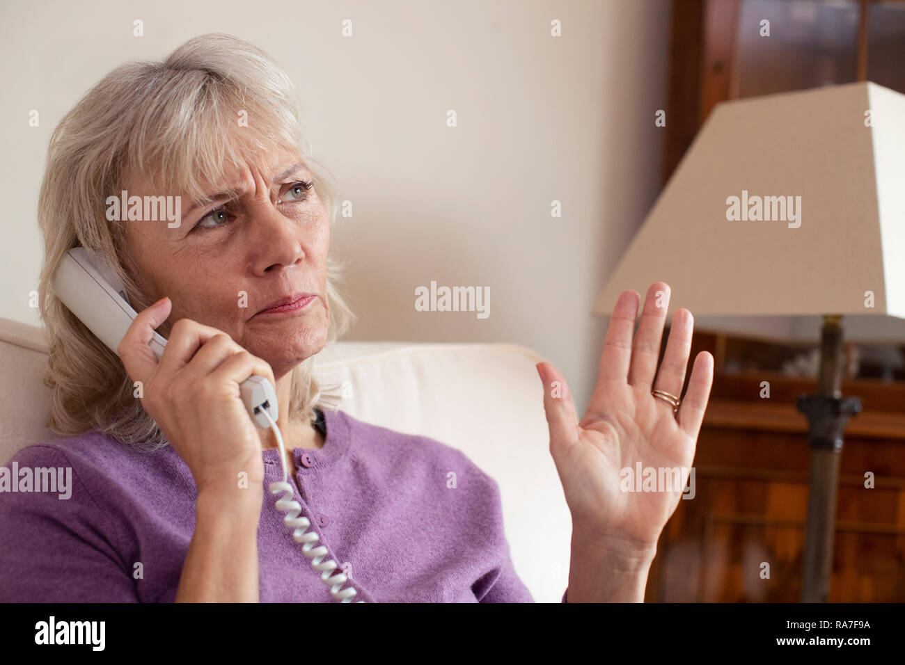 Ältere Frau den Empfang unerwünschter Anruf zu Hause Stockfoto