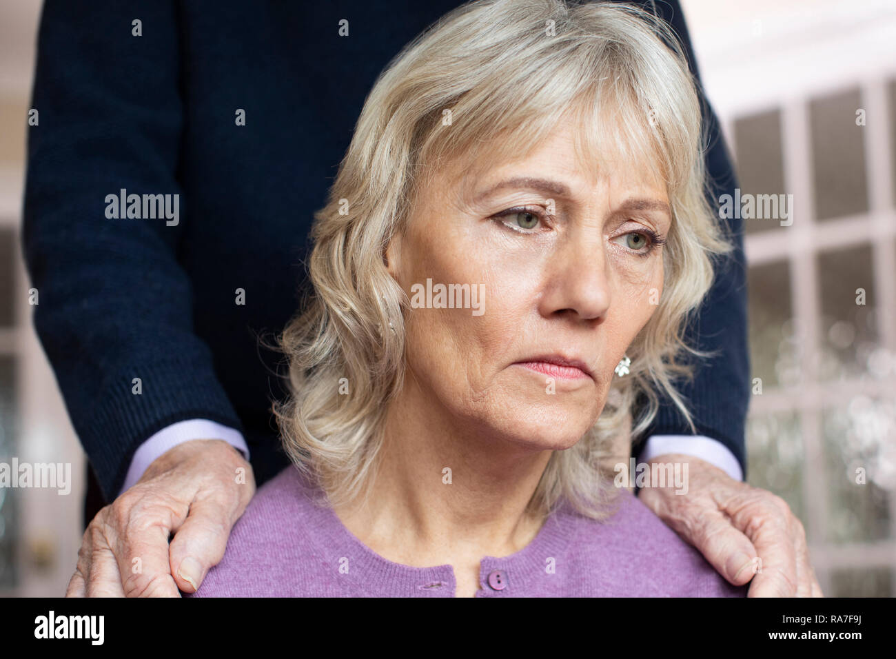 Verwirrte ältere Frau, mit Depressionen und Demenz wird getröstet durch Ehemann Stockfoto