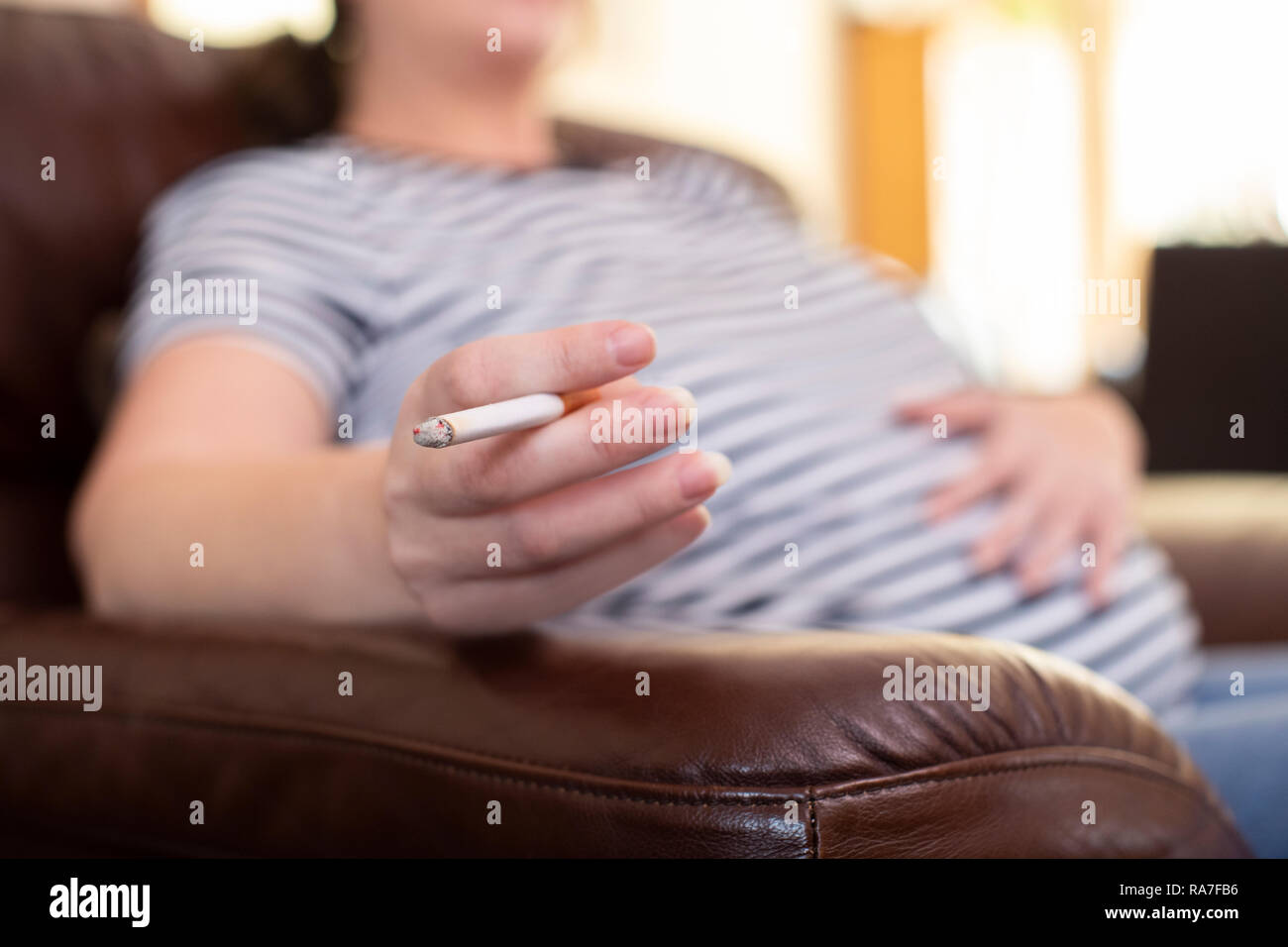 In der Nähe der schwangeren Frau zu Hause rauchen Zigarette Stockfoto