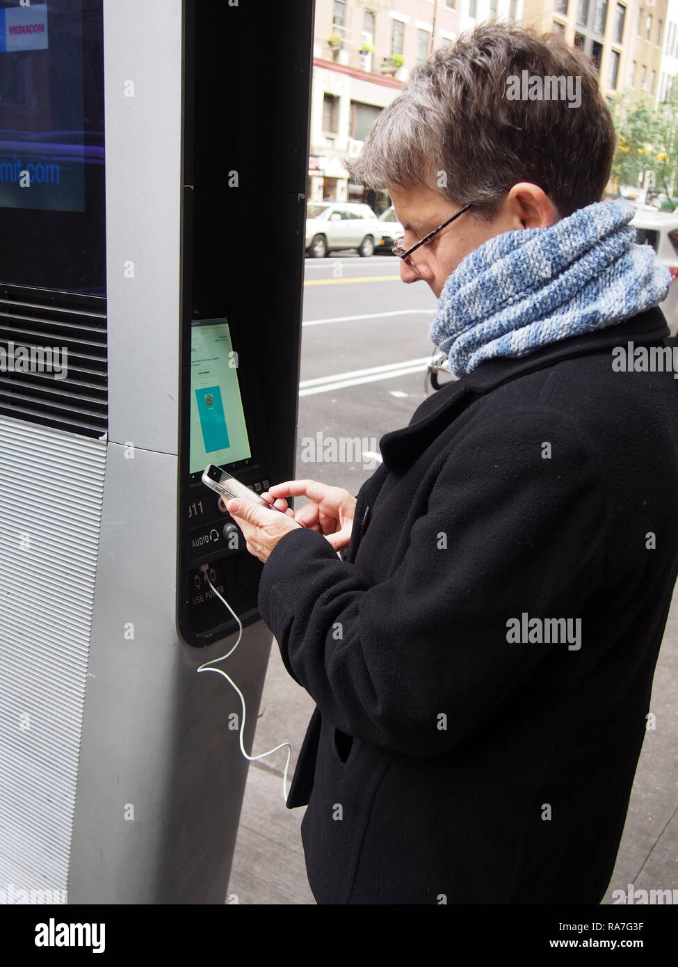 Frau mit LinkNYC Ladestation, Oktober 2018, © katharine Andriotis Stockfoto