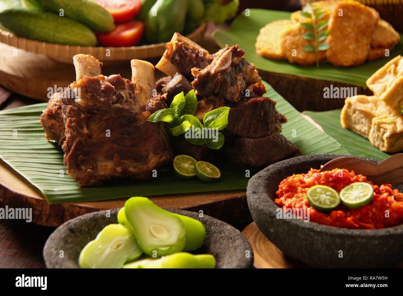 Iga Penyet. Javanisch gebraten - dann - zertrümmerte Rindfleisch Rippen mit roter Chili Paste und frischem Gemüse serviert. Stockfoto