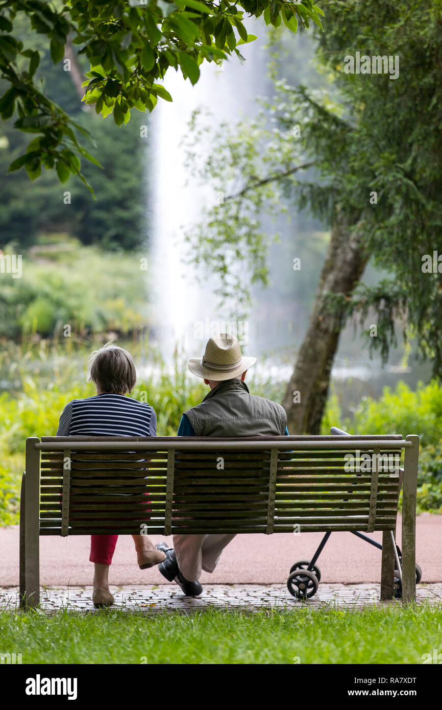 Senioren, Mann, Frau, mit rollator, sitzen in einem Park auf einer Bank, Stockfoto