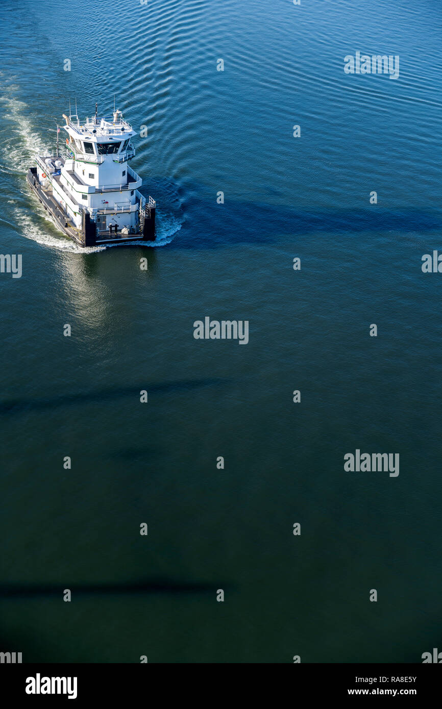 Das prächtige, moderne Schubschiff mit Decks und Kabinen mit Besatzung von Matrosen Schnitte durch die dunklen spiegelglatte Oberfläche des Spiegels ruhigen Wasser verlassen Stockfoto