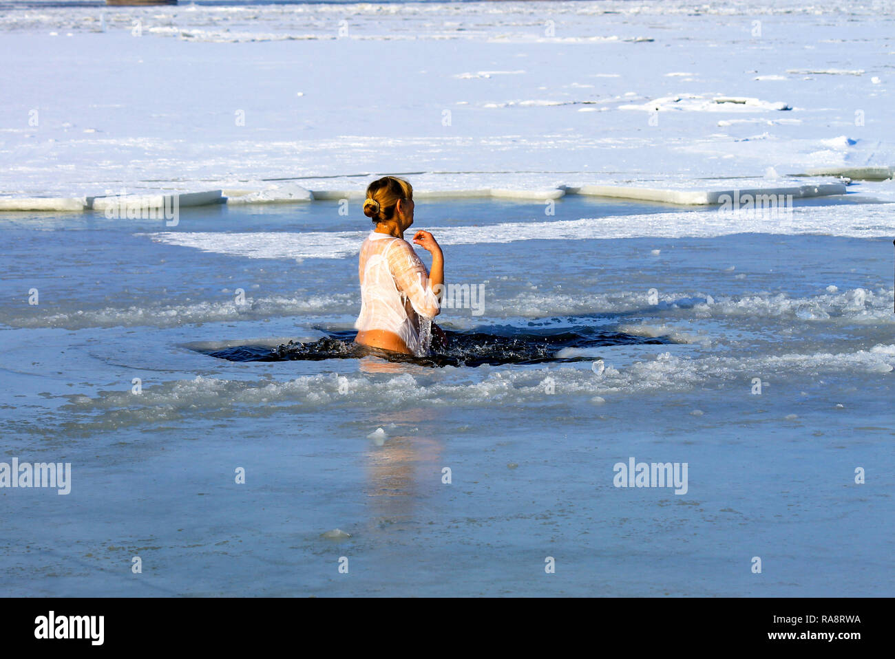 Winter Sport. Eine Frau schwimmt im Winter mit Eis während der Ferien der Epiphanie abgedeckt. Härten Stockfoto
