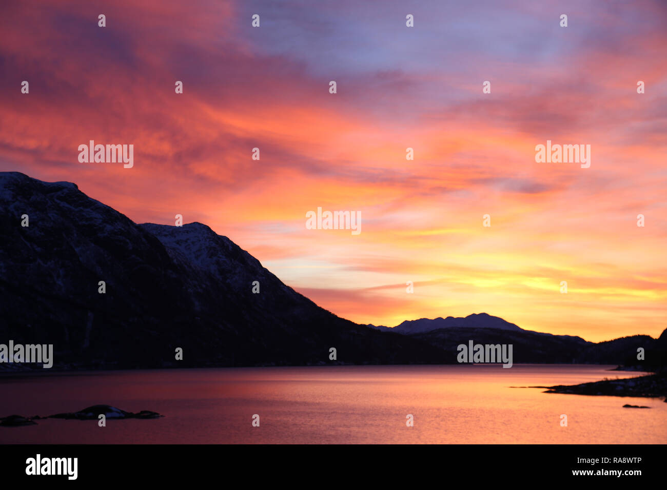 Atemberaubenden Sonnenaufgang über See und Berge Stockfoto
