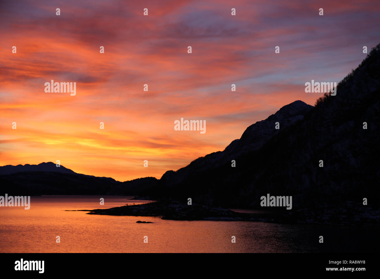 Atemberaubenden Sonnenaufgang über See und Berge Stockfoto