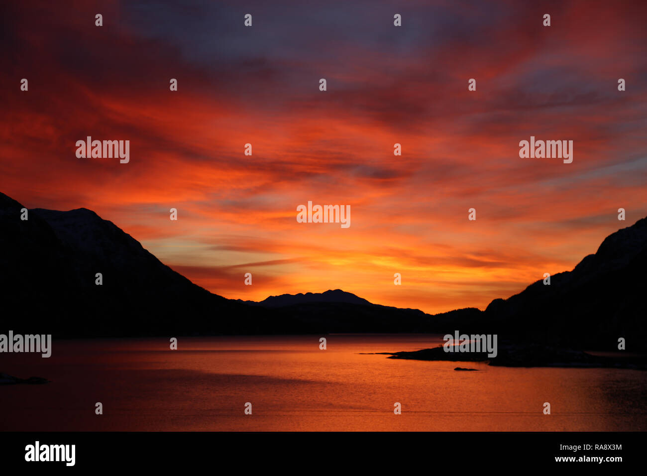 Atemberaubenden Sonnenaufgang über See und Berge Stockfoto