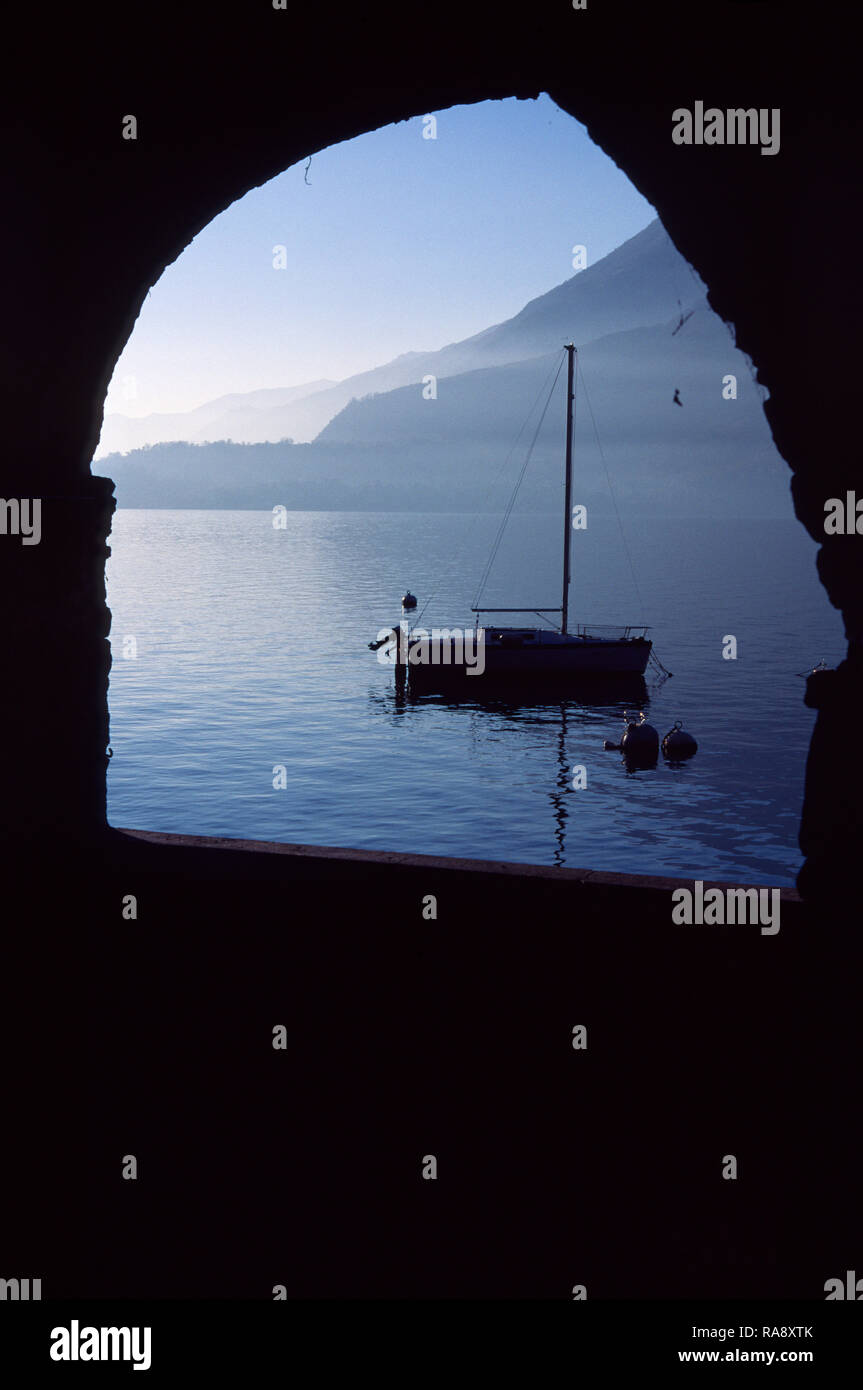 Schöne mit großen Fenstern und Blick auf den Comer See. Der Blick auf die friedvolle blaue See ist aus einem der alten Tunnel der alten Straße Neara am See. Stockfoto