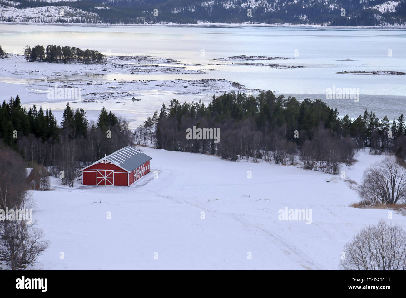 Norwegische Hütte am See im Schnee Stockfoto