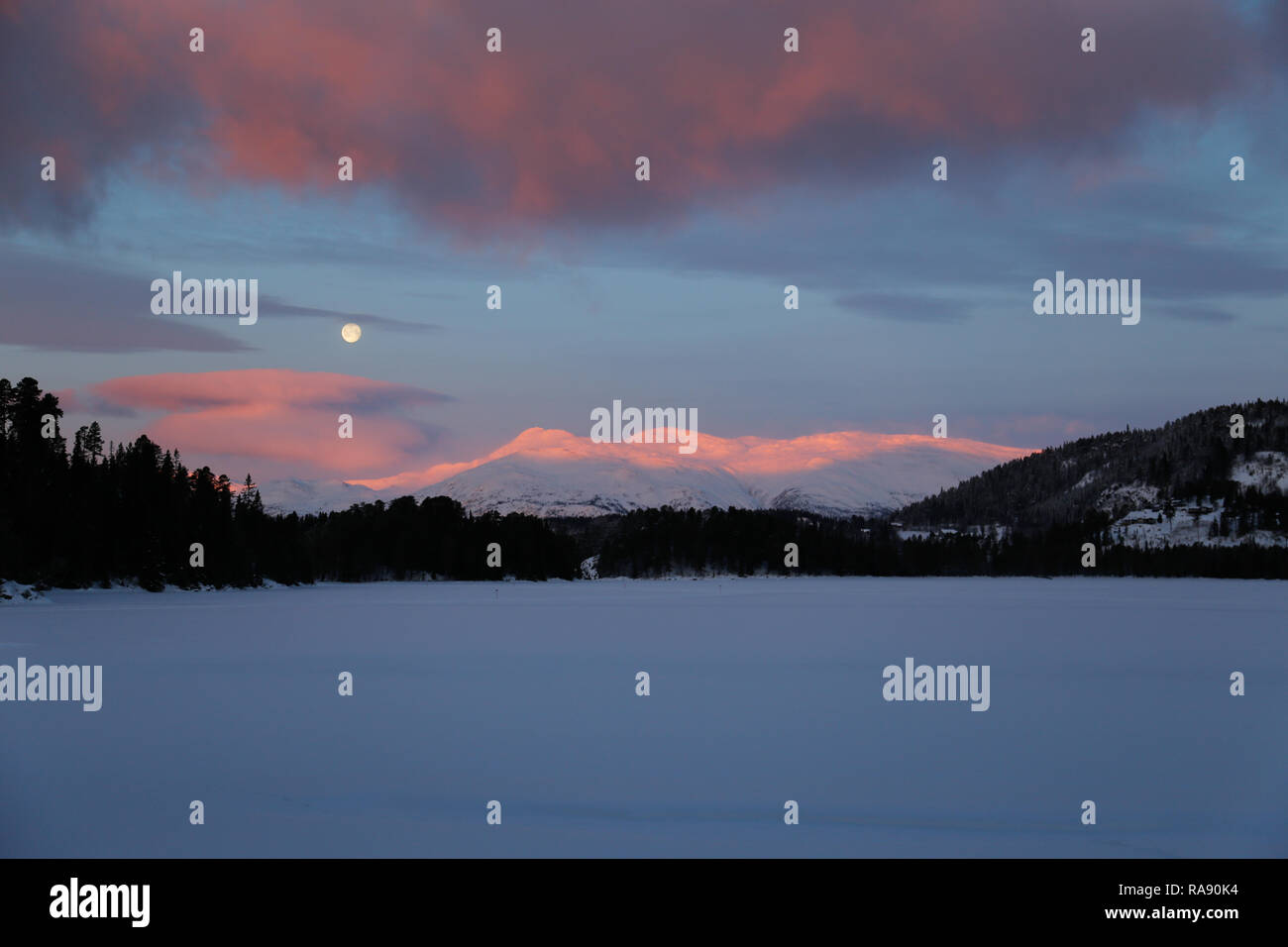 Mond in der Dämmerung Himmel über verschneite Berge Stockfoto