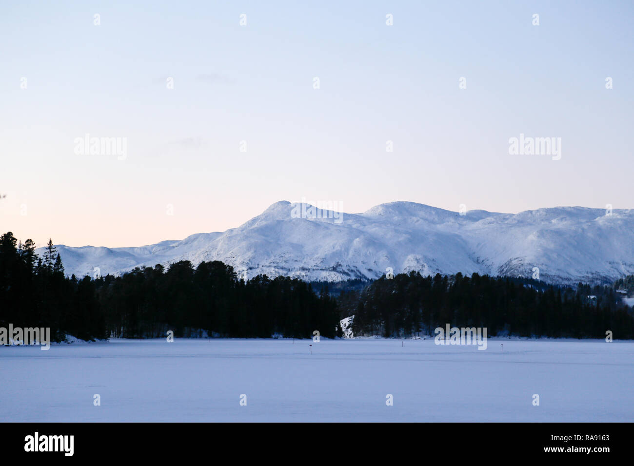 Morgen Blick auf schneebedeckte Berge hinter dem See Stockfoto