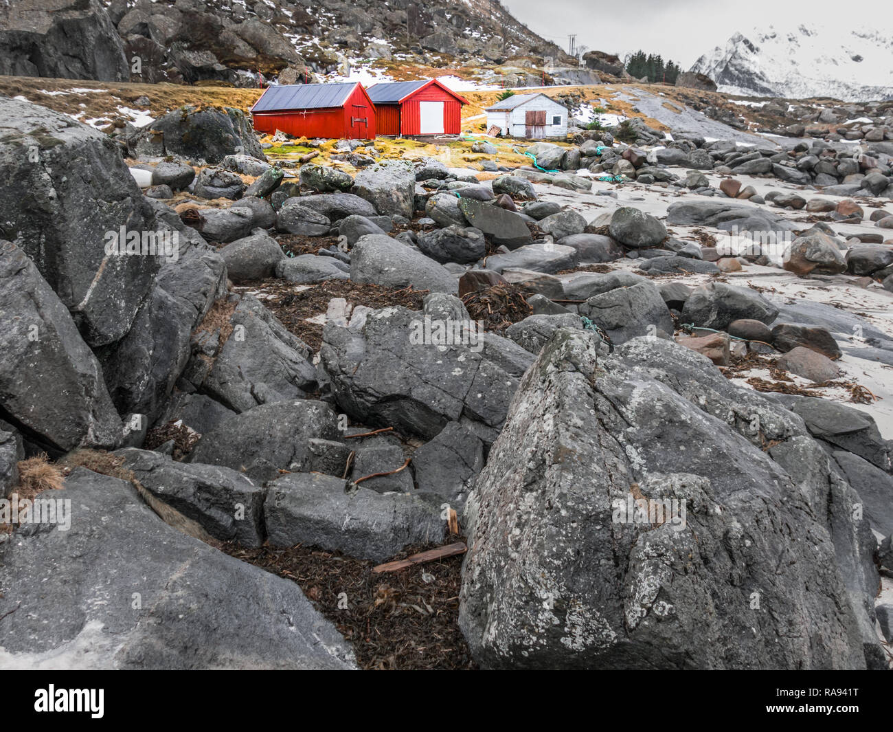 Rote Schuppen an der felsigen Küste von Brenna, Austvagoya, Lofoten, Nordland, Norwegen Stockfoto