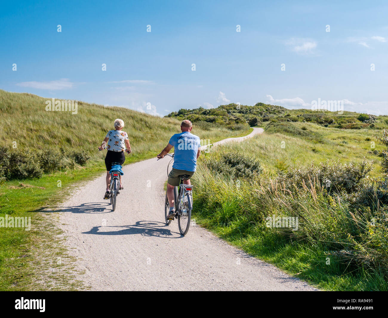 Ansicht der Rückseite des Menschen Fahrrad auf Radweg in Dünen von Naturschutzgebiet "Het Oerd auf die Westfriesische Insel Ameland, Friesland, Niederlande Stockfoto