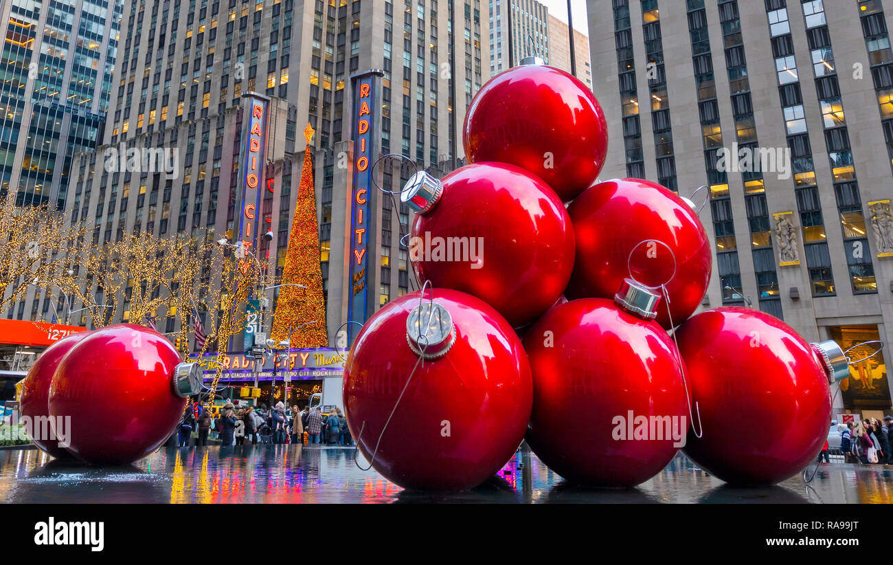 Riesige rote Weihnachtsverzierungen in der Nähe der Radio City Music Hall an der 6th Avenue in New York City. Stockfoto