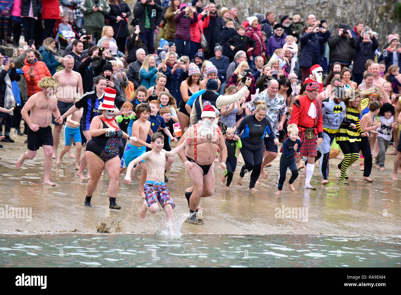 Schwimmer und Zuschauer am Tag der neuen Jahre Dip in Newquay Hafen Hafen in Newquay in Cornwall. Stockfoto