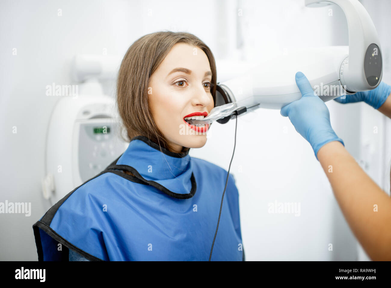 Junge Frau in Schutzkleidung x-ray Aufnahme eines Zahnes in der Zahnarztpraxis Stockfoto