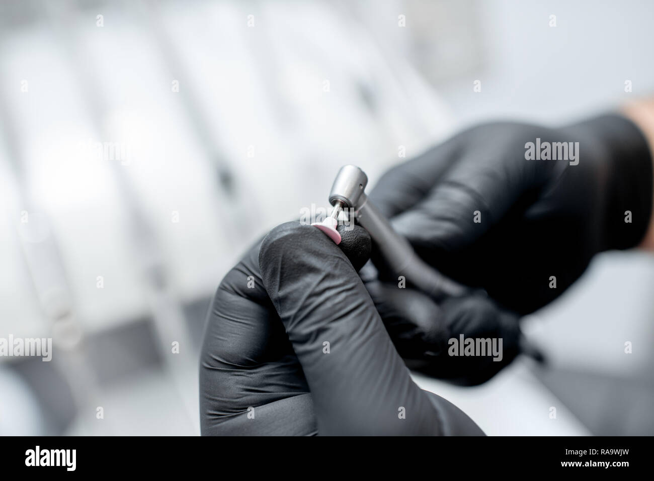Nahaufnahme einer zahnmedizinischen Bohrer mit Düse in die Hände in Schwarz medizinische Handschuhe Stockfoto