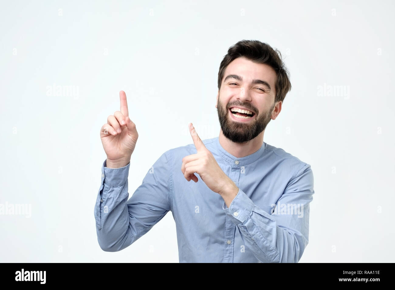 Mittleres Alter Mann lächelnd mit glücklichen Gesicht und verweist auf die Seite mit dem Finger Stockfoto