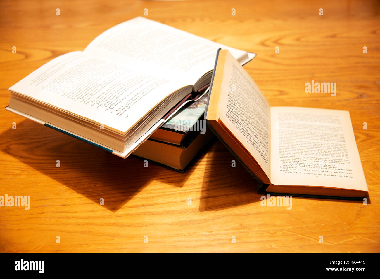 Eine offene Stapel Bücher auf einem Tisch gestapelt Stockfoto