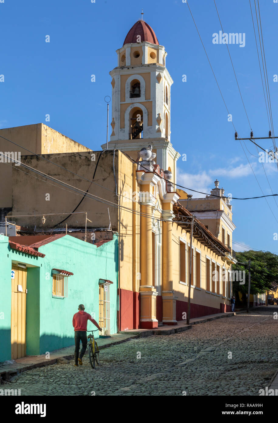 Man Walking Fahrrad entlang der Calle Boca unter Glockenturm des ehemaligen San Francisco Convent, Trinidad, Kuba Stockfoto