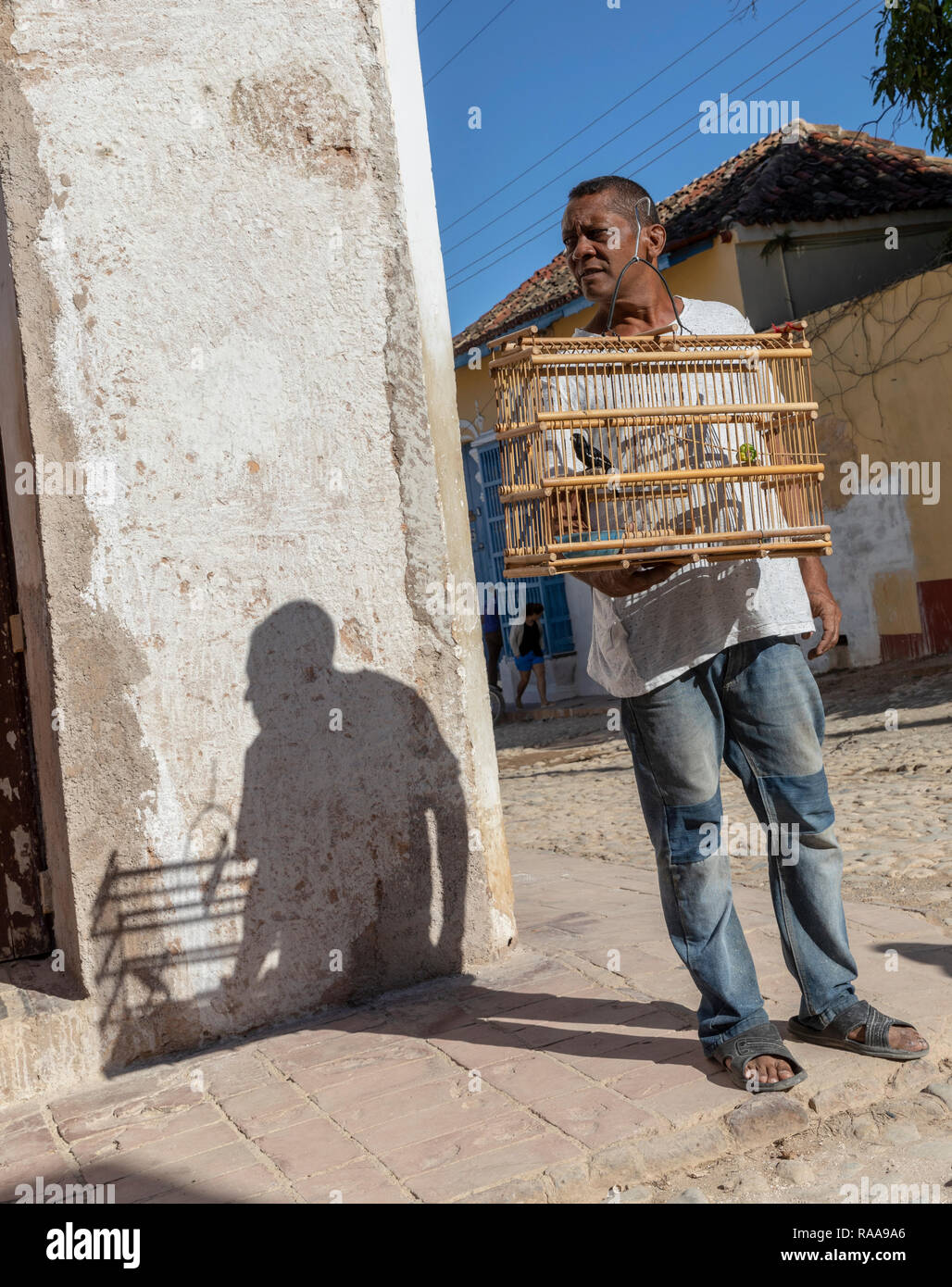 Man Walking Haustier Vogel im Vogelbauer, Calle San Jose, Trinidad, Kuba Stockfoto