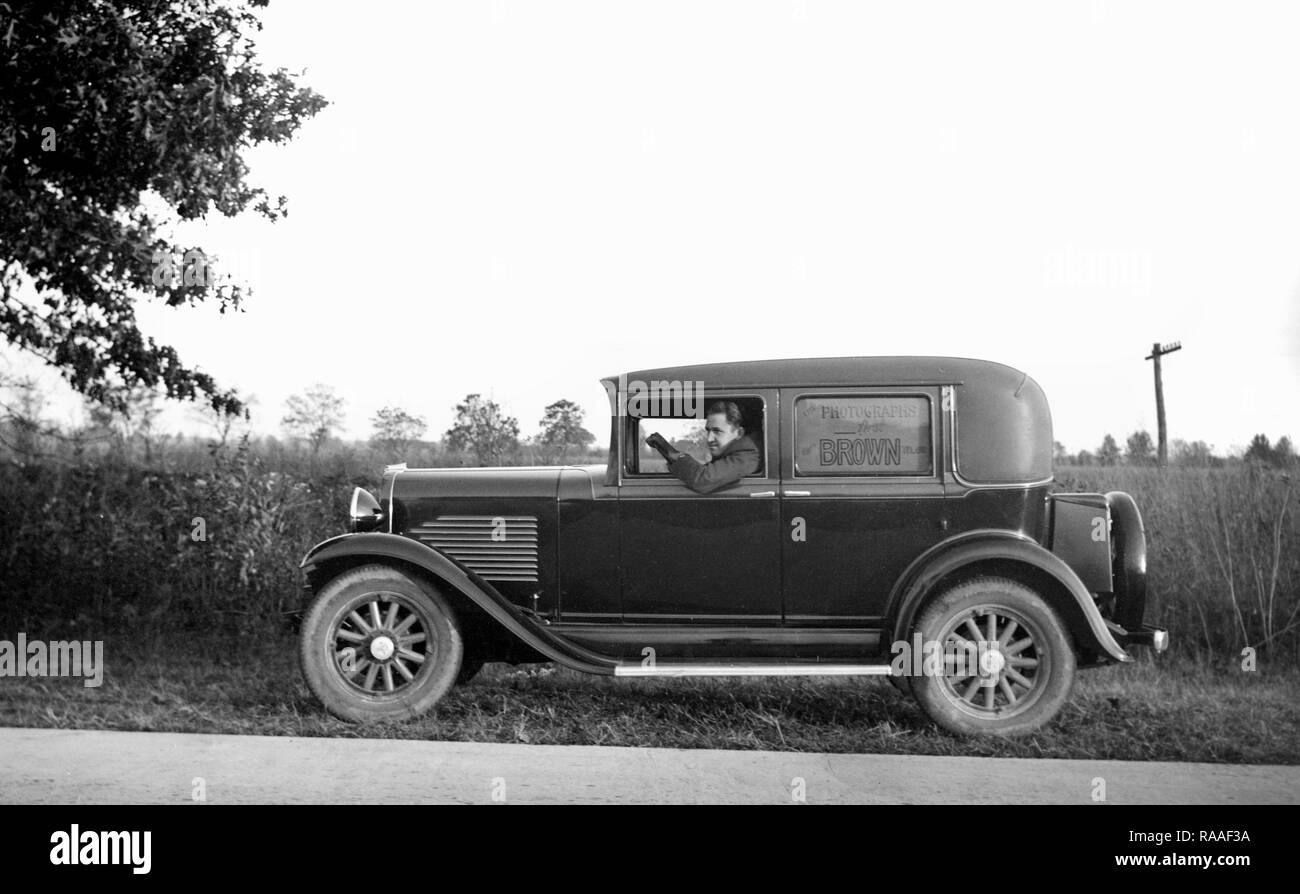 Fotograf Braun sitzt in seinem Auto entlang einer ländlichen Straße, Ca. 1930. Stockfoto