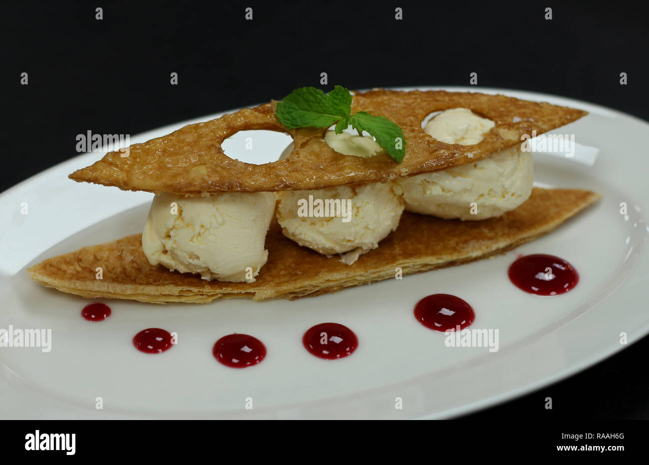 Vanilleeis, knusprige tuile, Himbeer Sauce Stockfoto