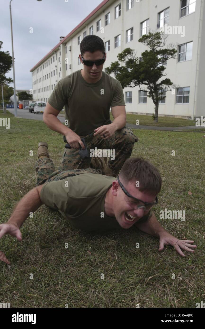 Us Marine Corps SSgt. James Lawracy, 3. die Strafverfolgungsbehörden Bataillon, Zeitformen und schreit, nachdem mit Taser Widerhaken als Teil der Non-Lethal Waffen Instructor Kurs auf Camp Hansen, Okinawa, Japan. Marines, Matrosen, Flieger und Japanische Sicherheitsbeamte abgeschlossen eine Woche lang Non-Lethal Waffen Instructor Kurs, der Taser Ausbildung, OC Belichtung und riot control Team Taktik. Stockfoto