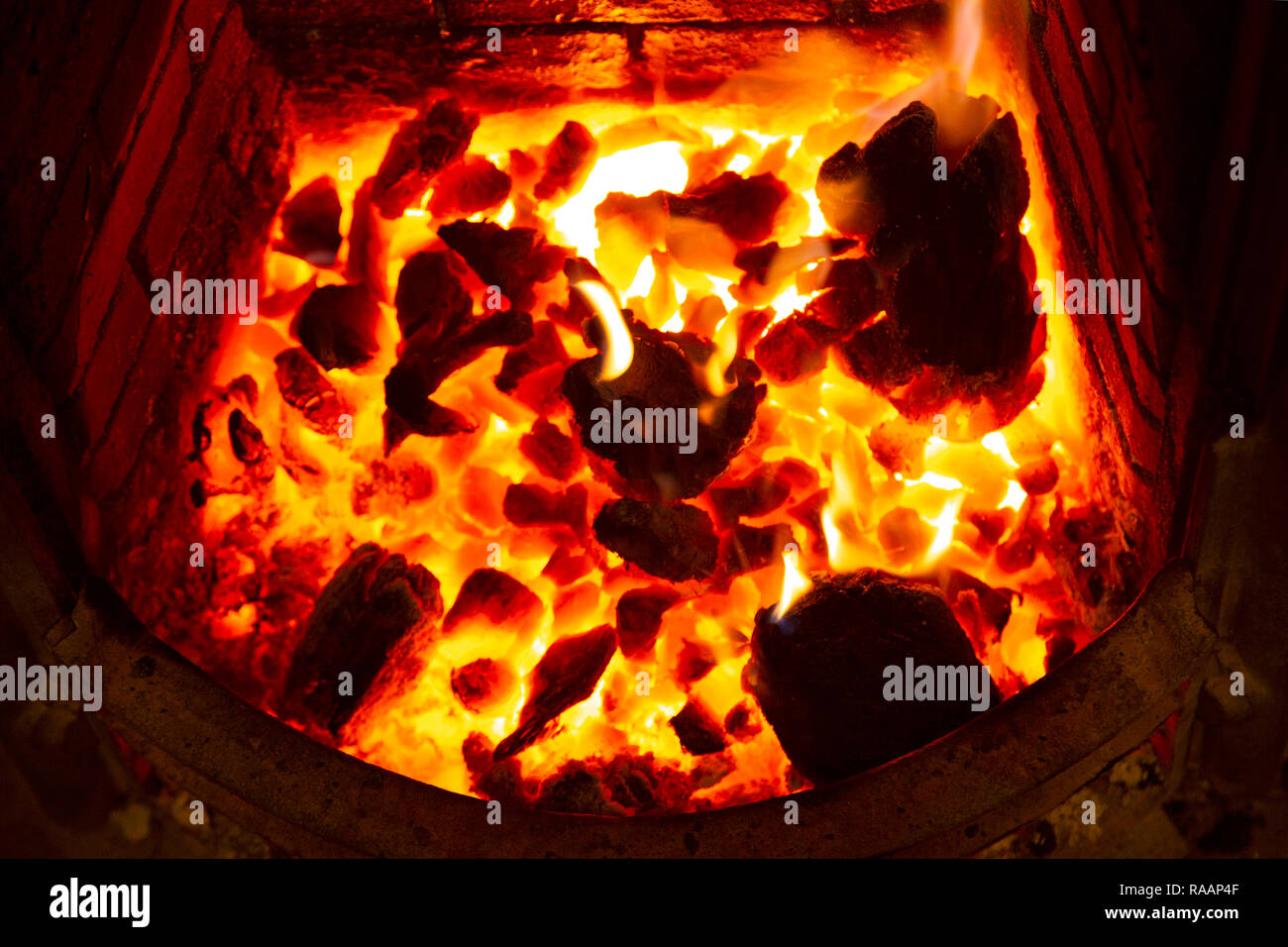 Ein offenes Feuer im Winter. Ebmers leuchten hell in der Feuerstelle. Stockfoto