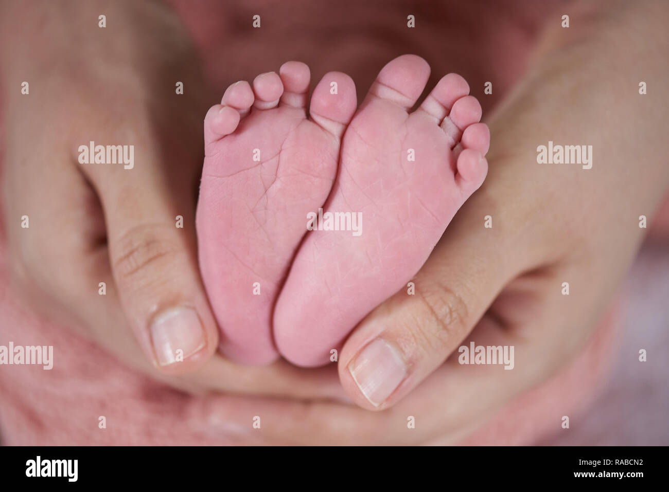 Eltern halten Neugeborene rosa Zehen Nähe zu sehen. Stockfoto