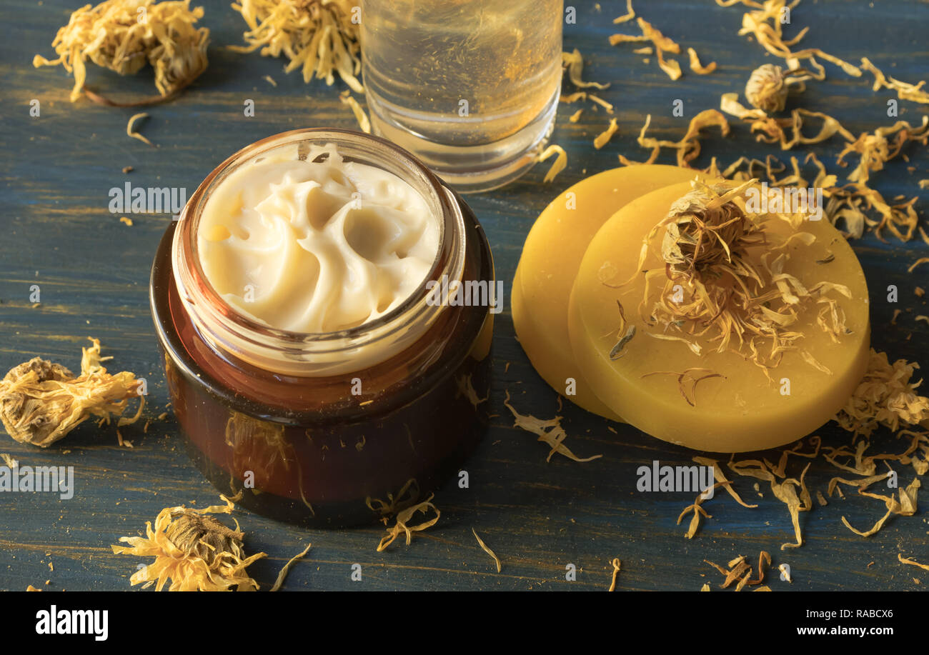 Gesichtscreme von Ringelblume und Bienenwachs aus Holz, auf einem blauen Hintergrund Stockfoto