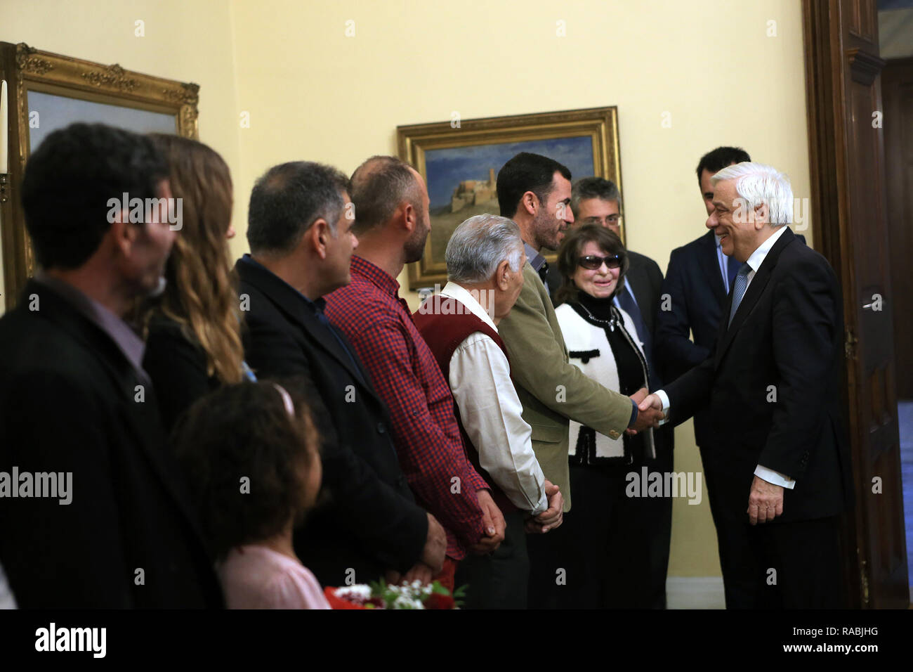 (190103) - Athen, Januar 3, 2019 (Xinhua) - griechische Präsident Prokopis Pavlopoulos (1. R) erfüllt und gratuliert den drei Fischer und ihre Familien am Presidential villa in Athen, Griechenland, Jan. 2, 2019. Ägypter Nachfrageseite El Khamisi, 50, Mahmoud Moussa, 46, und albanischen Jeka Gani, 35, ihr Leben riskiert, neben vielen anderen einheimischen Fischern am Juli 23, 2018 Rettung Dutzende von Menschen auf der Flucht vor den Flammen, die durch den Küstenort Mati, rund 30 Kilometer nordöstlich von Athen gefegt. Hundert Menschen in den Flammen starben oder das Meer, der Abend. Griechische Präsident Prokopis Pavlopoulo Stockfoto