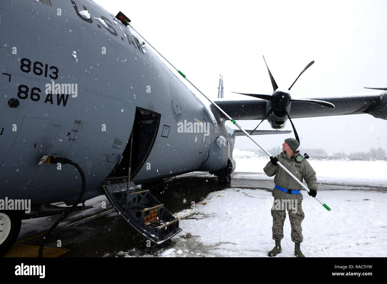 Airman 1st Class Jakob Taatjes, 86th Aircraft Maintenance Squadron Crew Chief, entfernt der Schnee von einem Super C-130J Hercules Flugzeuge an der Air Base Ramstein, Deutschland, Jan. 10, 2017. Kontinuierliche schweren Schnee bestand während der Mehrheit der Tag mit der Aufforderung, die Schneeräumung in der Basis.. Stockfoto