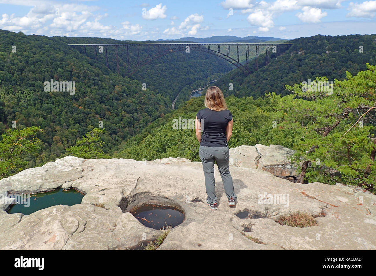 Junge Frau genießt die Aussicht auf den New River Gorge Bridge vom Ende der Long Point Trail in West Virginia. Stockfoto