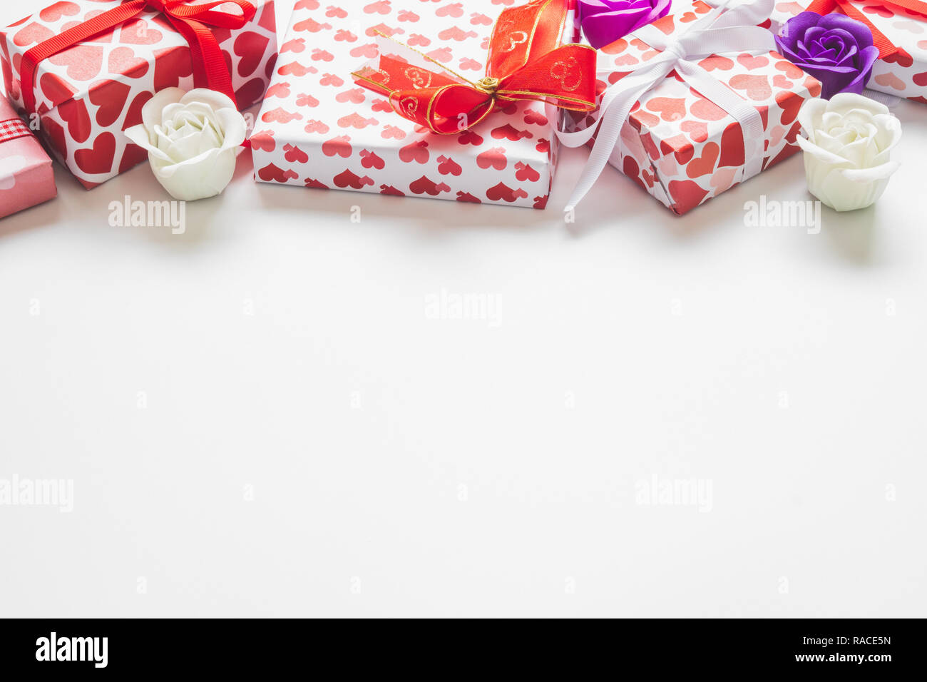 Valentinstag Hintergrund mit Geschenkboxen mit Herzen Form Papier wrapper und Rosen auf weißem Hintergrund. Stockfoto