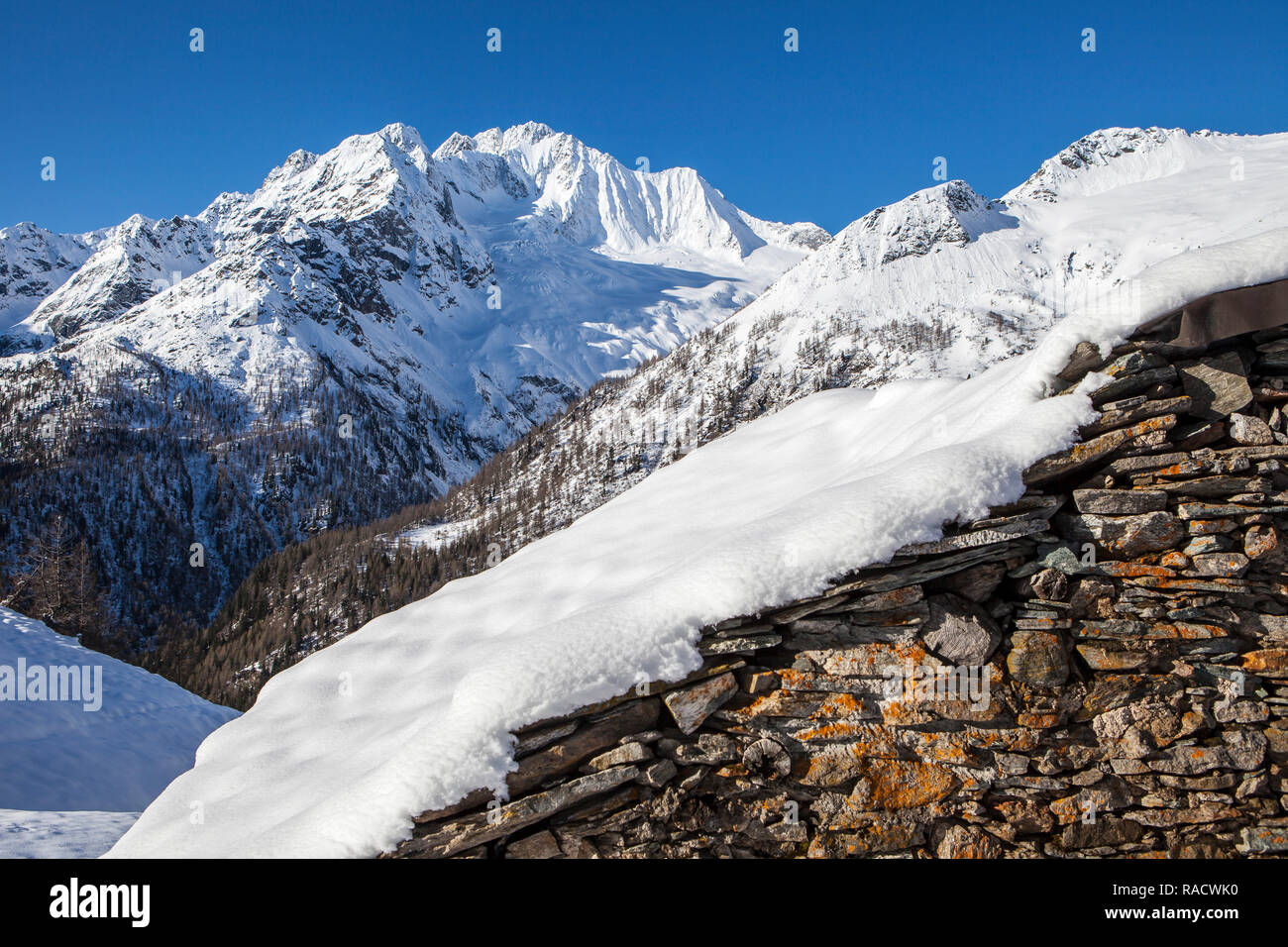 Hütte aus Stein mit Schnee mit Monte Disgrazia auf Hintergrund, Alpe dell'Oro, Valmalenco, Valtellina, Lombardei, Italien, Europa Stockfoto