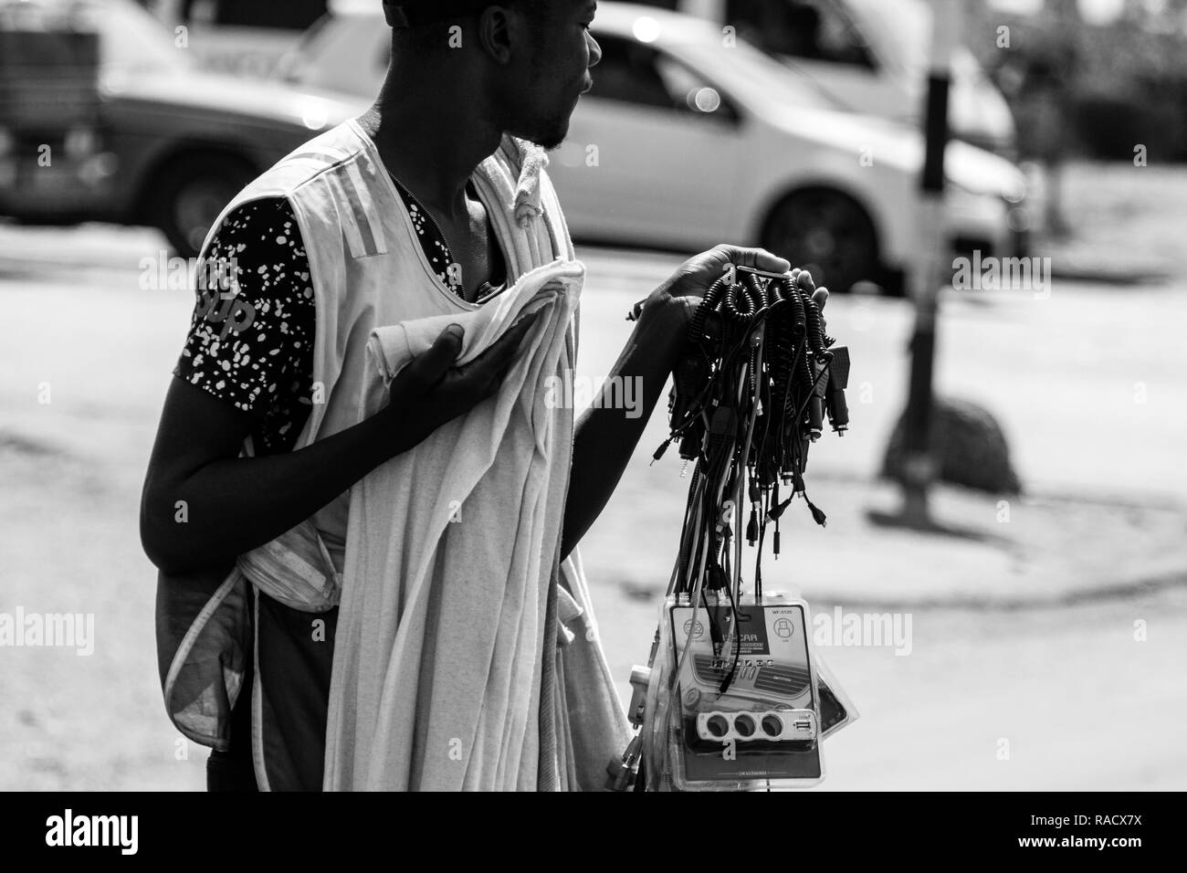 Harare, Simbabwe - 23 Sep 2018: Junge Simbabwe Straßenhändler verkauft seine eingeführte elektronische Waren an einer Ampel aufgrund von Arbeitslosigkeit. Stockfoto