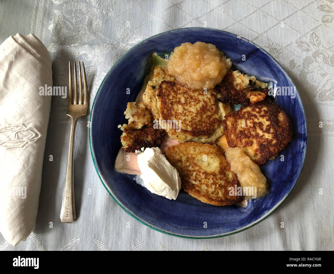 Latkes mit Apfelmus und Sauerrahm. Latkes waren ein traditionelles Essen in den Osteuropäischen Ländern Russland, Polen, Österreich und Deutschland. Stockfoto