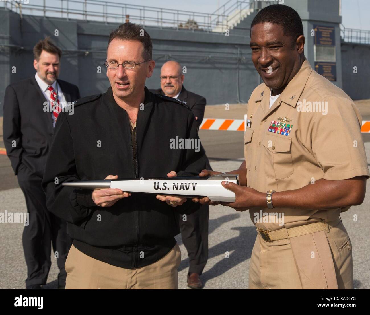 DAHLGREN, Va-Konteradmiral David Hahn, Leiter der Naval Research und Kapitän Godfrey 'Gus' Weekes, NSWCDD kommandierenden Offizier, halten eine elektromagnetische schienenkanone Projektil während Hahn besuchen Sie zu NSWCDD, 31.01.12. Der Admiral führte sein Amt des Naval Research (ONR) Delegation zu sehen, neue und aufkommende ONR geförderten Technologien entwickelt an NSWCDD, einschließlich gerichtete Energie und die elektromagnetische schienenkanone. Sie paßte auch Ingenieure eine hypervelocity Projektil aus einem 5-Zoll-, 62-Kaliber öffnen gun Mount am Potomac River Test Range Feuer. Stockfoto