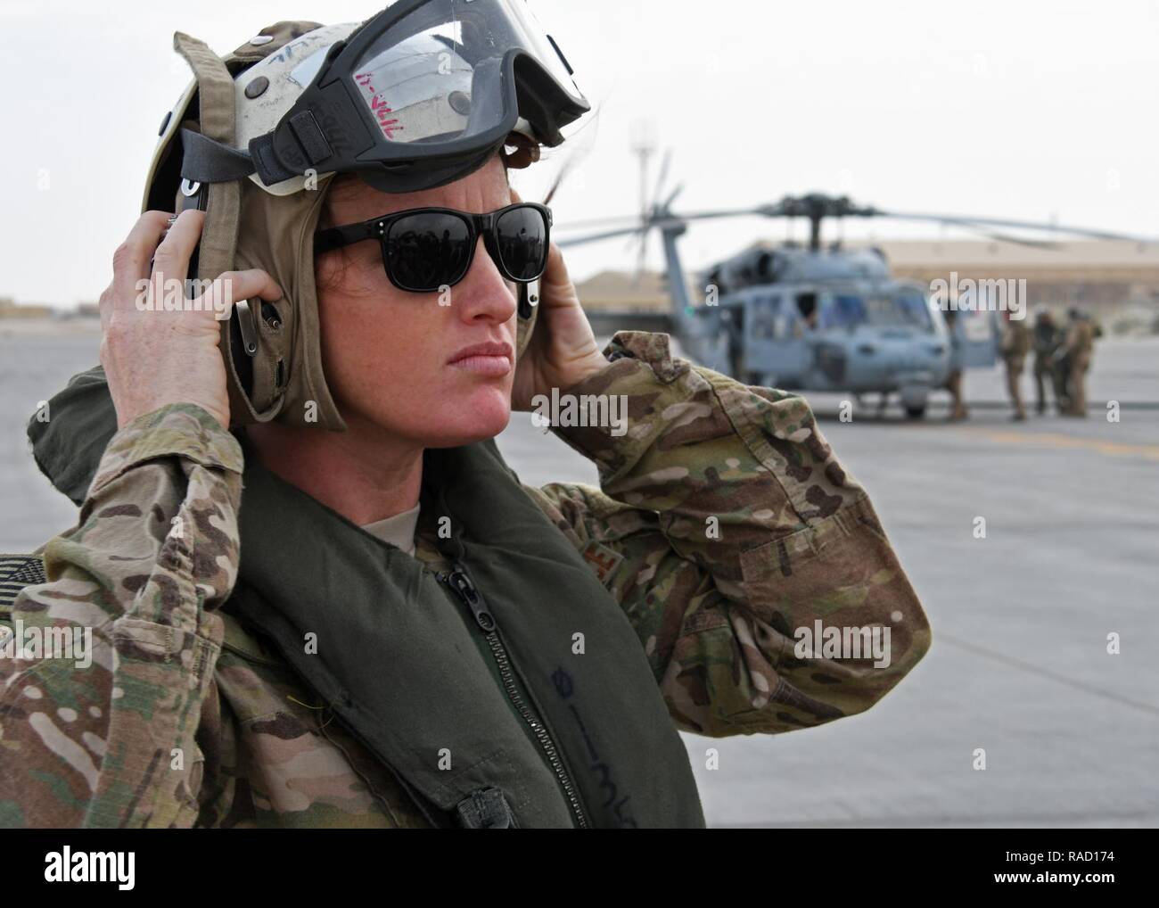 Us Air Force 1 Lt Bridget Henry, ein Critical care Krankenschwester mit der 379 Expeditionary medizinische Gruppe, zieht ein Helm während eines Fluges Safety briefing im Al Udeid Air Base, Katar, Jan. 23, 2016. Henry war Teil eines mobilen, OP-Team - expeditionary Critical Care Team die Teilnahme an einer Übung an Bord der HMS Ocean, Flaggschiff der Royal Navy. Stockfoto