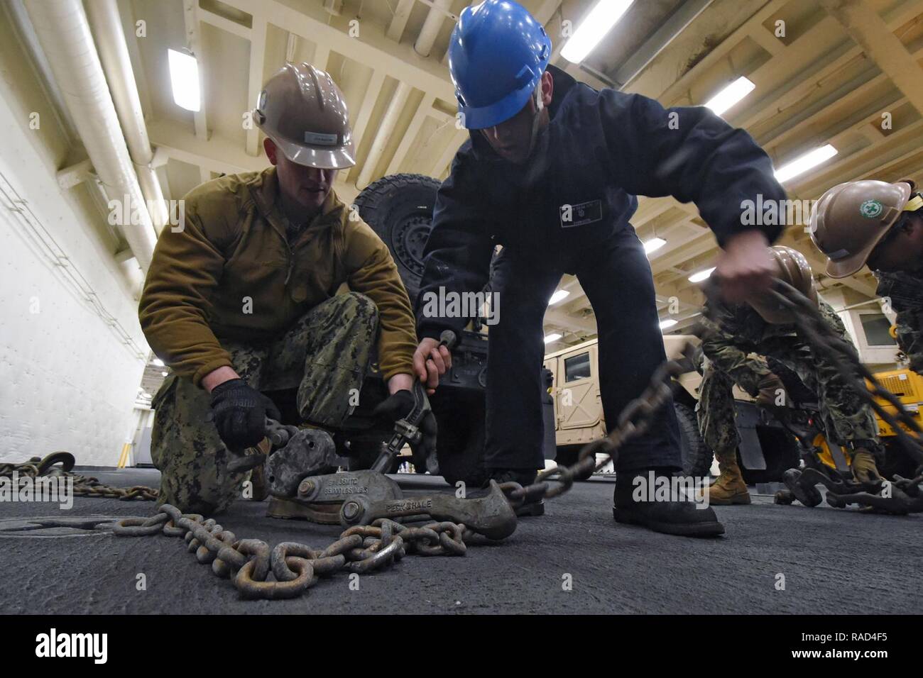 PORT HUENEME, Calif (Jan. 26, 2017) - seaman Recruit Jancarlo Sanmartin, zugeordnet zu den amphibious Transport dock Schiff USS San Diego LPD (22), Züge Equipment Operator Constructionman Marcus Johnson, Naval Mobile Konstruktion Bataillon (NMCB) 4, zugeordnet, wie schwere Ausrüstung zu, das Deck zu sichern Sie Griffe. San Diego und Naval Construction Group (NCG) 1 in einer Verteidigung Unterstützung der zivilen Behörden (DSCA) Last Übung (LOADEX) am Naval Base Ventura County Einarbeitung und Schulung für amphibische Landung Aktionen im Fall einer Naturkatastrophe vorzubereiten teilgenommen. Stockfoto