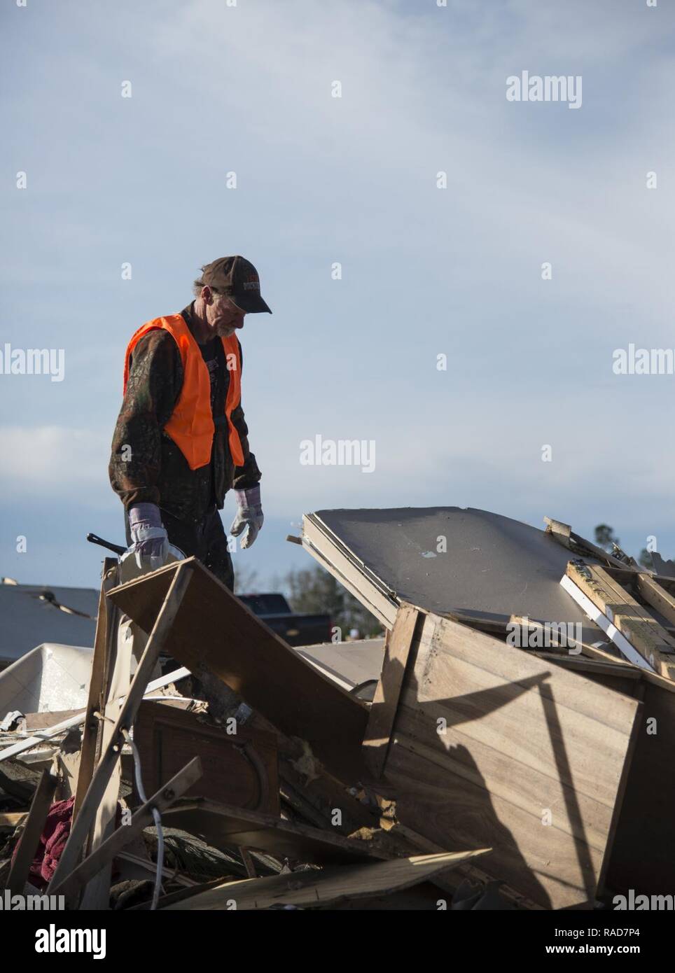 Ein freiwilliger steht auf einem Haufen von Schutt, nach einem Tornado, Jan. 28, 2017, in Adel, Ga. Der Tornado getötet, 15 Personen und wurde später ein EF3, der stärksten Tornado in der Geschichte der Grafschaft zu berühren. Stockfoto