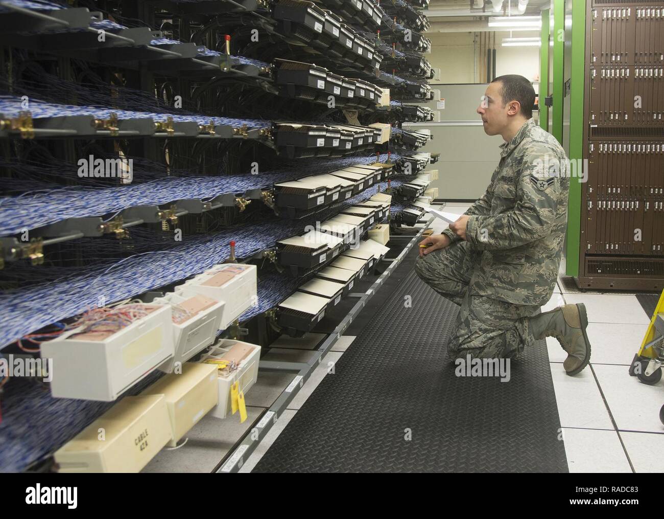 Airman 1st Class Kevin Kieser, 88th Communications Squadron Telefon Werkstatt voice network System Technician, sucht der Hauptverteiler für eine bestimmte Telefonleitung, Probleme, Jan. 27, 2017, at Wright-Patterson Air Force Base, Ohio. Jede blaue und weiße Kabel serviert mit mehr als 20.000 Wright-Patterson Telefonleitungen. Stockfoto