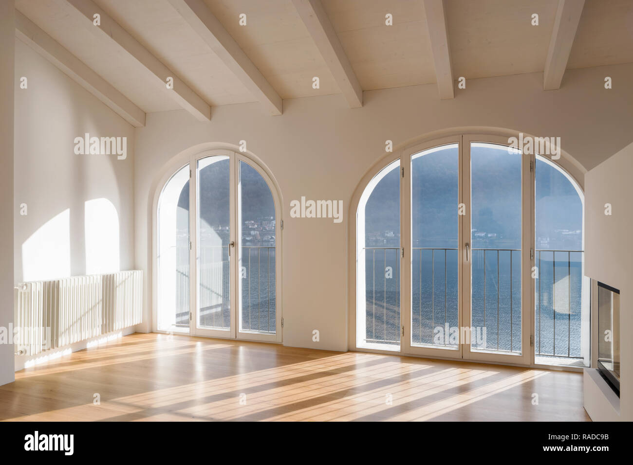 Leere Zimmer mit einem großen Fenster mit Blick auf den See. Antike  Holzbalken an der Decke einer renovierte Wohnung Stockfotografie - Alamy