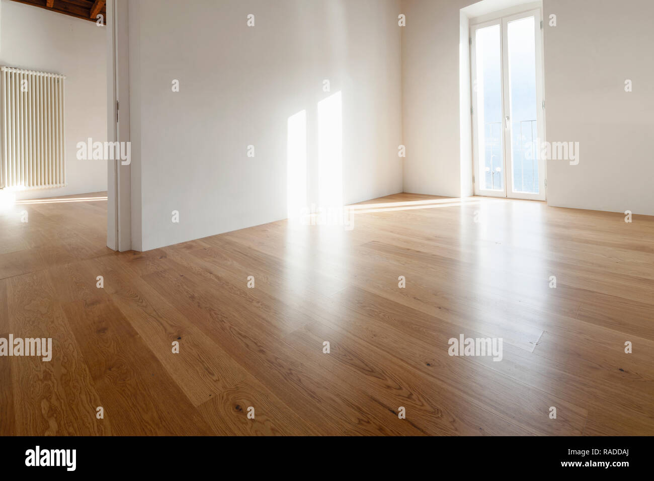 Leere Zimmer mit einem großen Fenster mit Blick auf den See. Antike Holzbalken an der Decke einer renovierte Wohnung Stockfoto