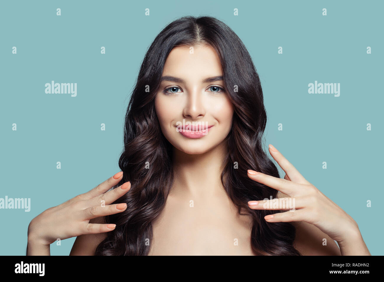 Junge hübsche Frau mit langen gesundes Haar und natürliches Make up auf blauem Hintergrund. Happy brunette Mädchen, Haar- und Schönheitssalon Hintergrund Stockfoto