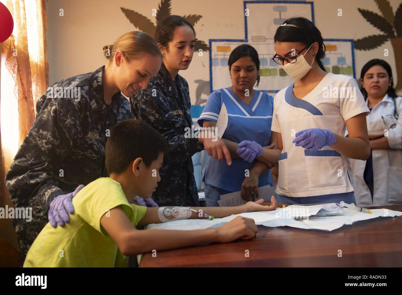 TRUJILLO, Honduras (31. 13, 2018) - Lt Melissa Mathers (links) und Lt. j.g. Karen Jimenez Gudino (Mitte links), Krankenschwestern, die Hospital Ship USNS Comfort (T-AH 20), erläutern die Reinigungsverfahren für einem peripher Eingefügt zentralvenösen Katheter (PICC) Linie auf einen jungen Patienten zu lokalen Honduranischen Krankenschwestern während ein Experte auf einem Exchange (SMEE). Die SMEE wurde zwischen U.S. Navy Vertrauensärzte und honduranischen Ärzten in einem Krankenhaus vor Ort durchgeführt. Komfort ist auf einem 11-Woche medizinische Unterstützung Mission in Zentral- und Südamerika als Teil des US Southern Command's Enduring Promise Initiative. Werde Stockfoto